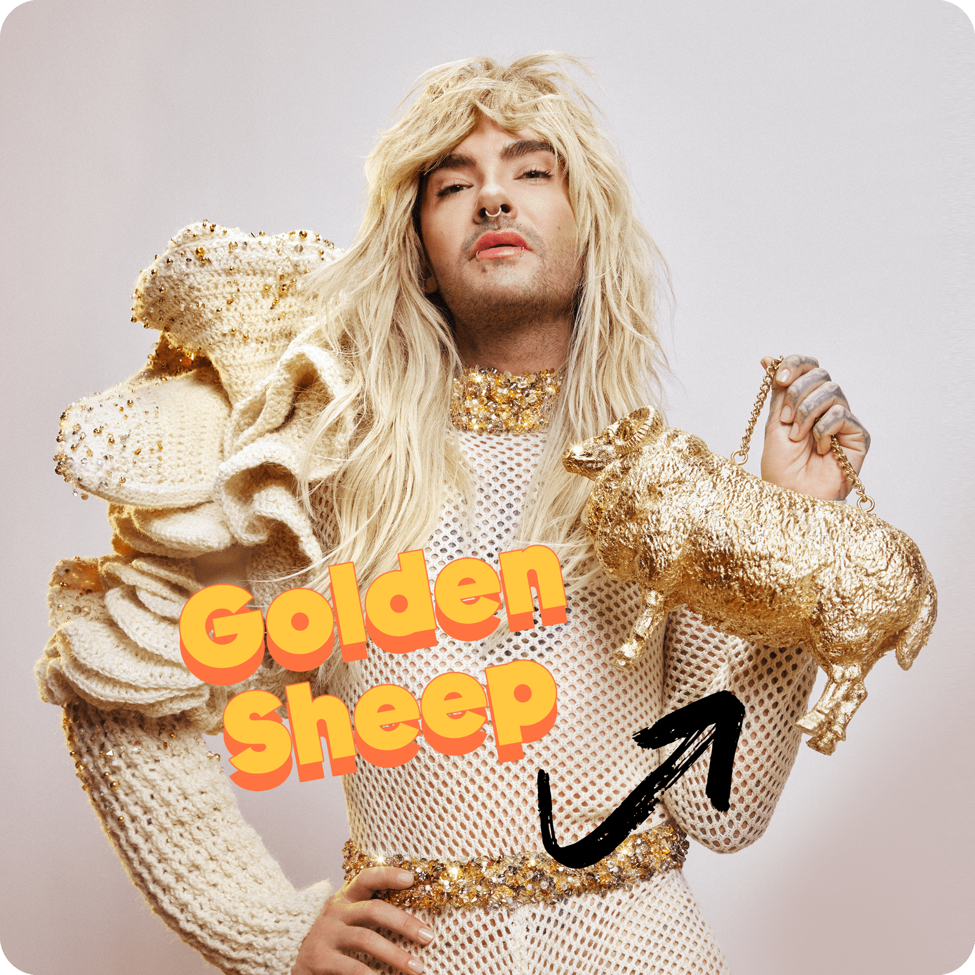 Bill Kaulitz is looking straight into the camera in front of a white wall, holding a golden sheep.